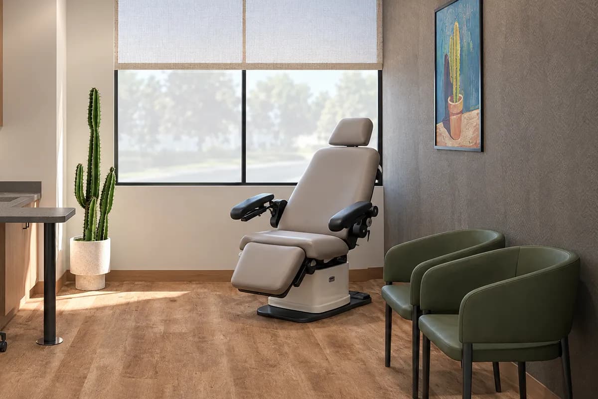 A power procedure chair in the window corner of a treatment suite at Alta Medical, with two guest chairs beside it